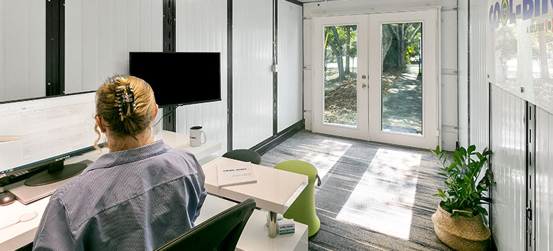 Worker at desk inside Cool-Binz mobile office