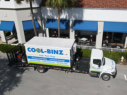further distanced and elevated shot of cool binz storage container sitting on truck flatbed on the side of commercial restaurant