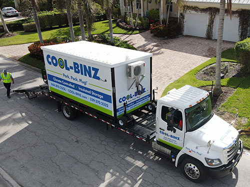 diagonal elevated shot of cool binz refrigerated bin getting unhitched from truck bed by employee