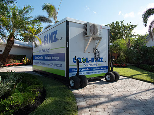 rear view of cool binz insulated storage container sitting on top of dolly wheels parked on residential looping driveway