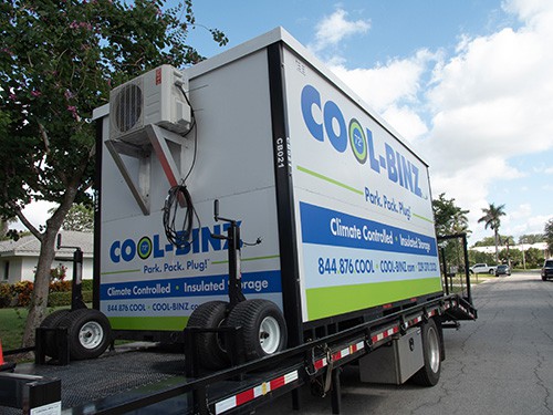 angled shot of a cool binz insulated storage bin sitting on top of truck flatbed parked in front of a house