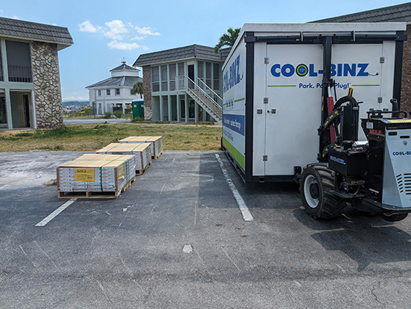 A COOL-BINZ worker standing by a climate controlled bin with traffic cones around